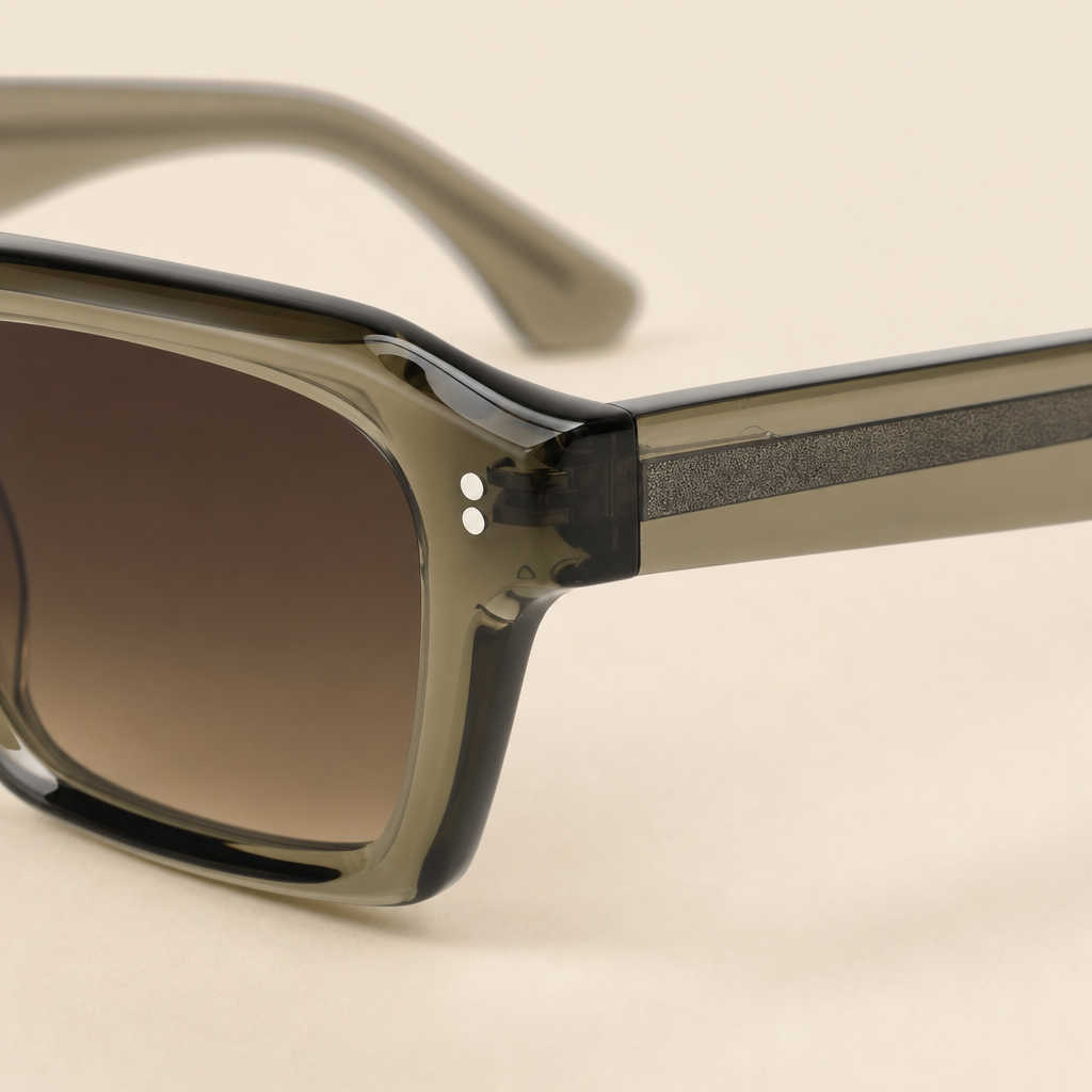 CLOSE-UP DETAIL OF 2005 AMBER SUNGLASSES SHOWING OLIVE-GREEN ACETATE AND SILVER DOT DETAIL AT THE FRONT.